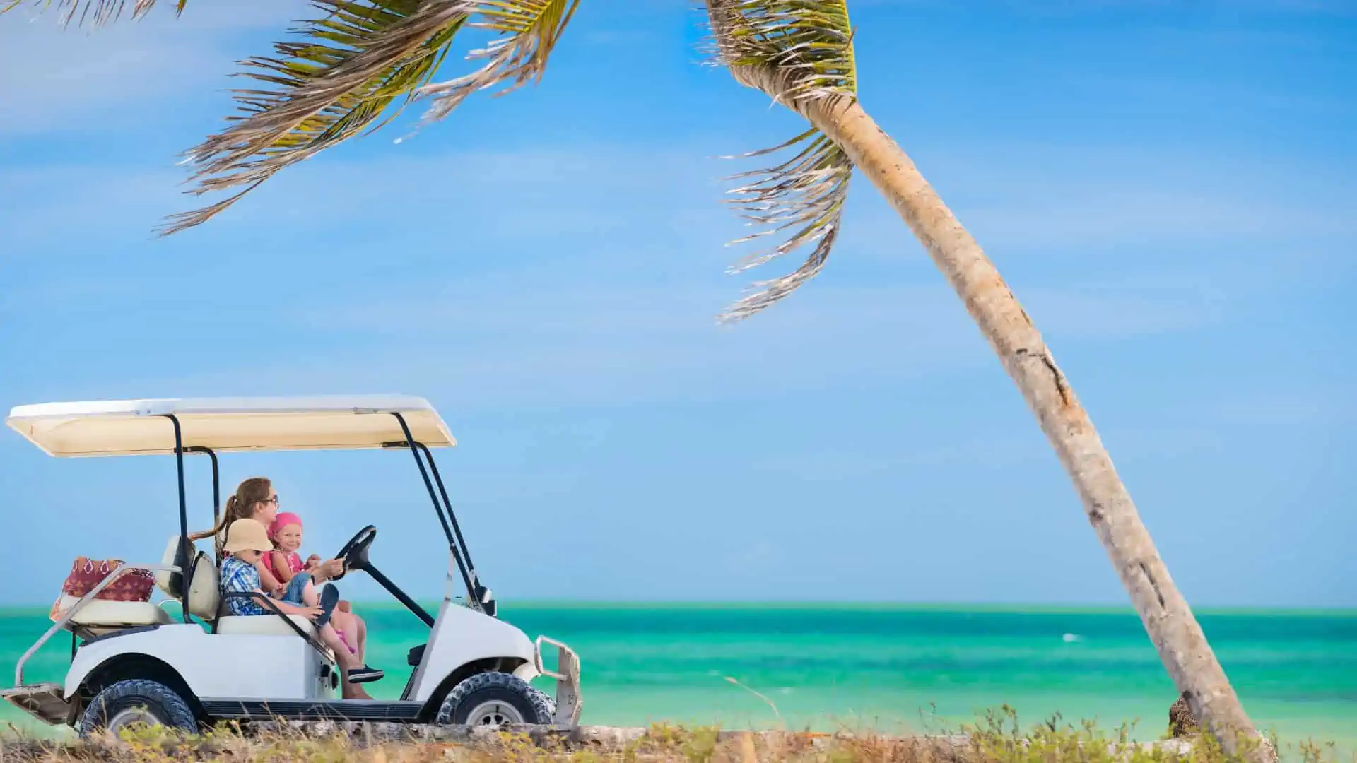 Best Golf Cart Fans - showing golf cart and family on a hot beach with palm trees