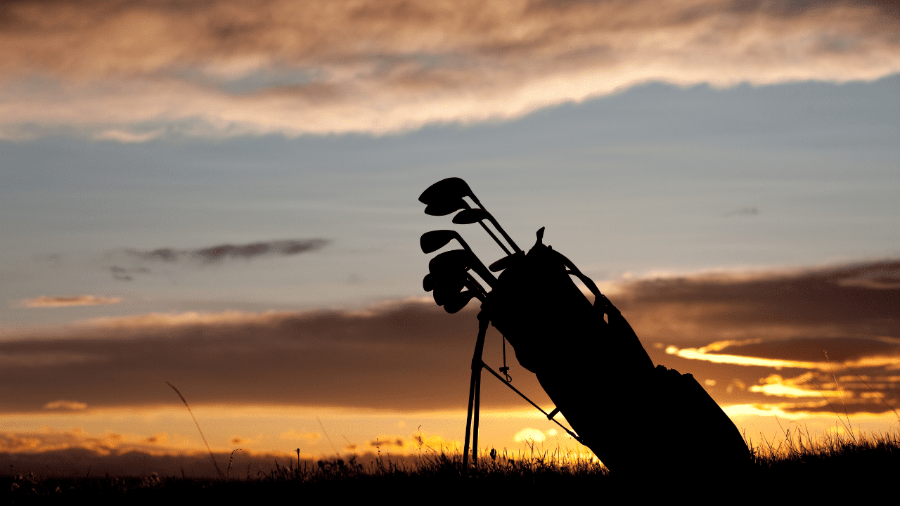 best golf clubs for seniors - showing sunset with golf bag in the distance.