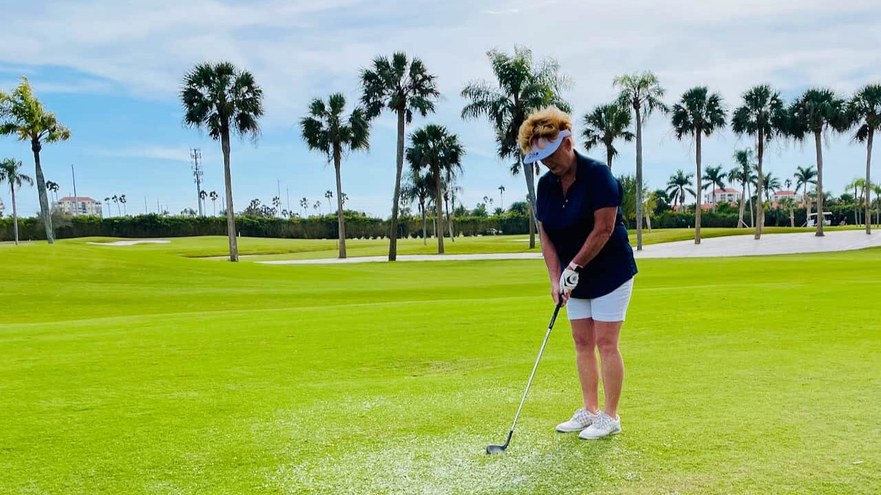 Woman Golfer using her golf chipper on a beautiful Florida Golf Course, Isla Del Sol.