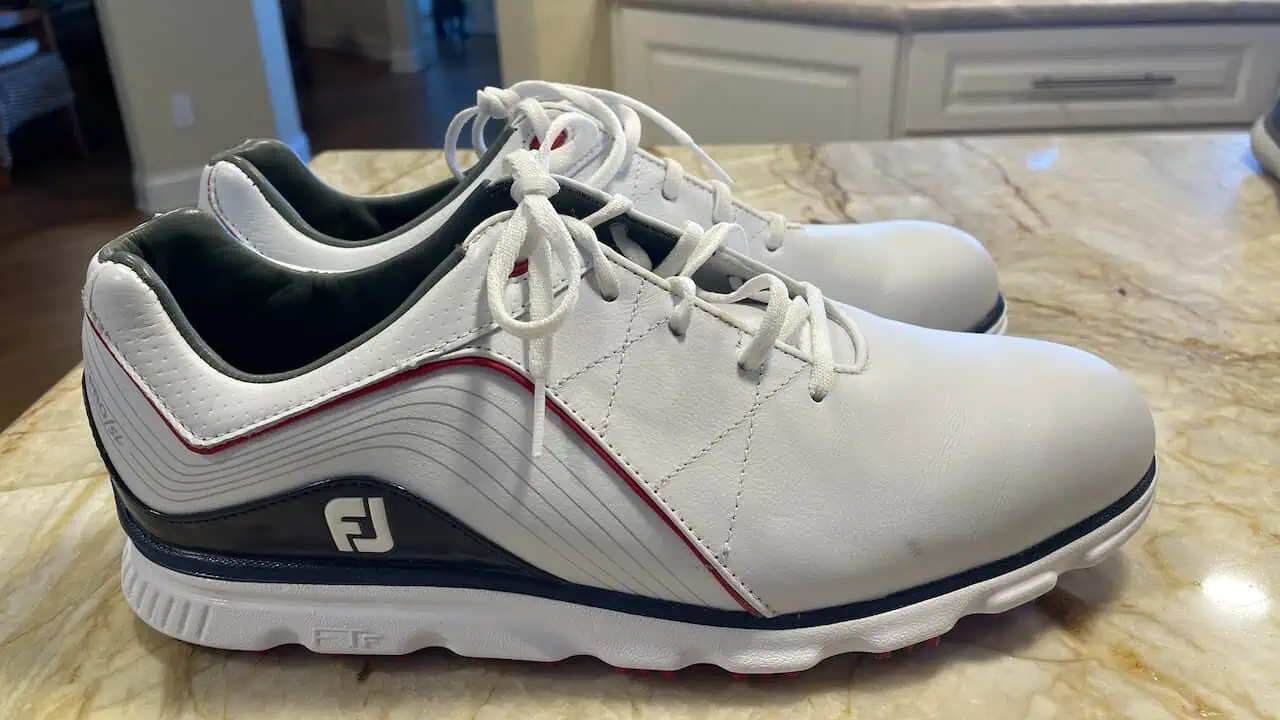 Best golf shoes for flat feet, showing foot joy shoes we use (men's in white and blue)