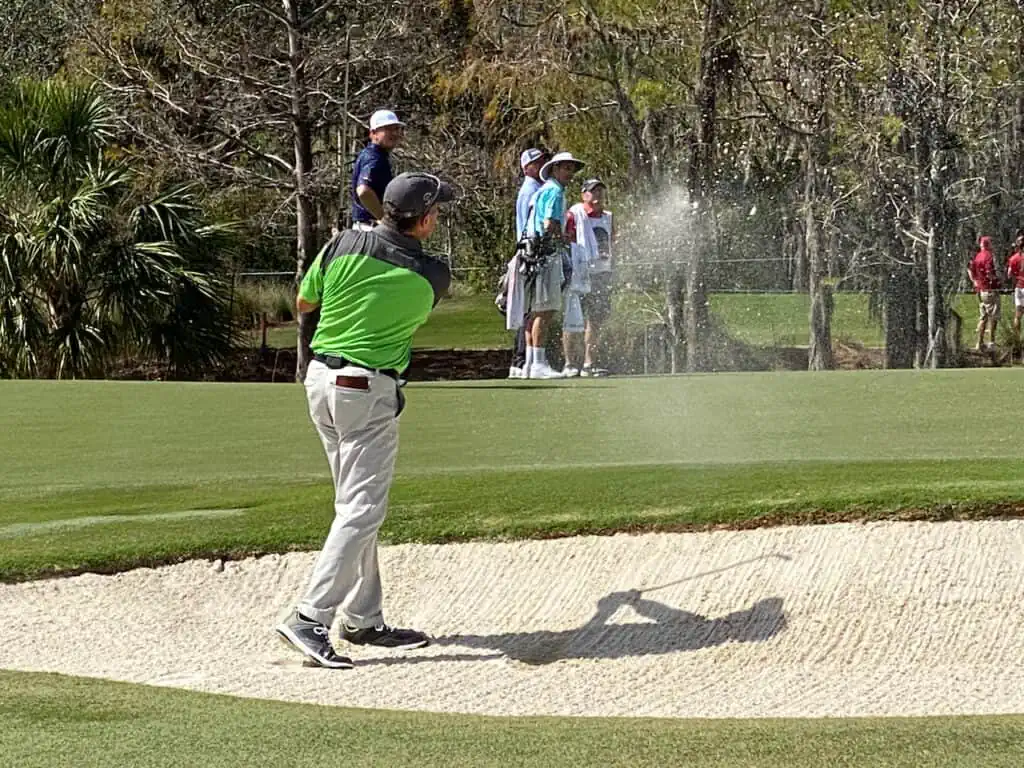 Scott Dunlap hitting his golf irons out of the bunker 