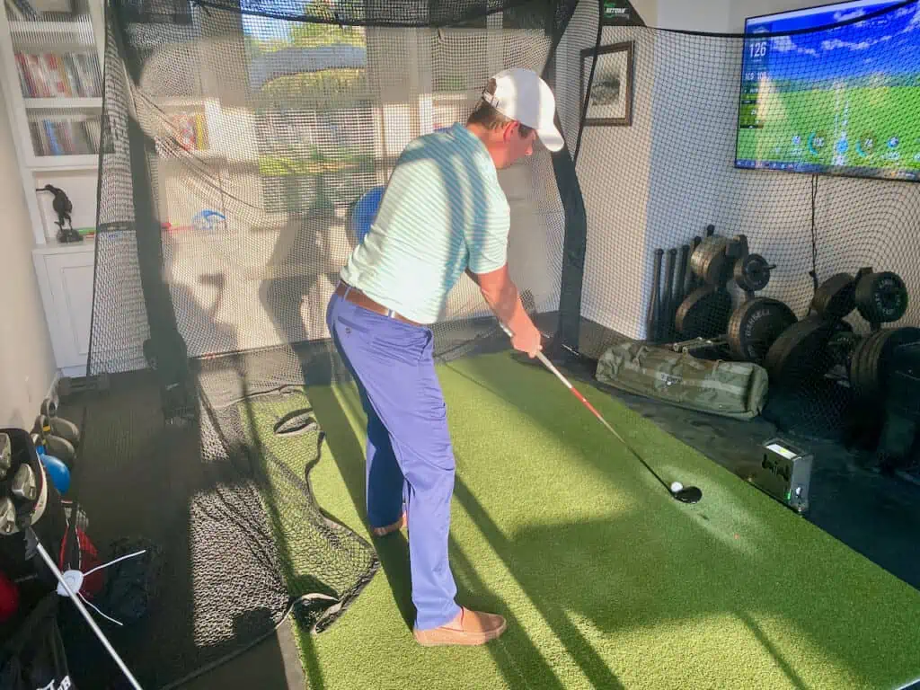 Single plane golf swing for seniors showing the set up on an indoor golf simulator. 