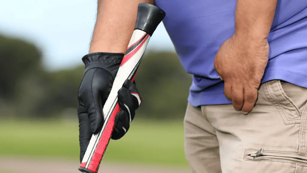 one-handed golfer using a jumbo golf grip with ball retriever on the end of the putter.