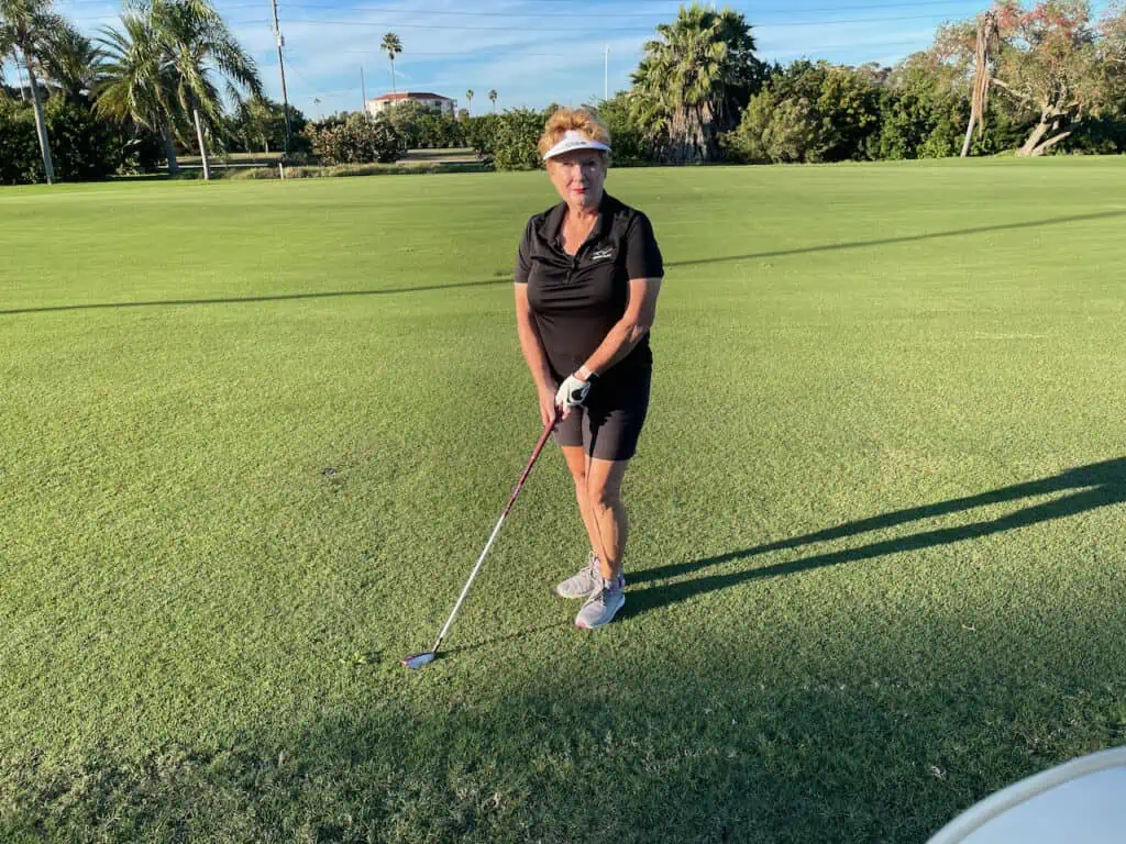 Golfer, Colleen Gilbert stands on the course with her golf club