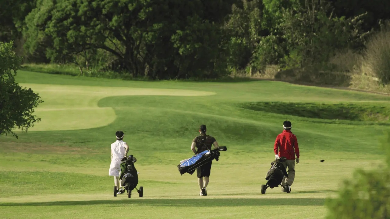 three golfers walking the fairway to the green