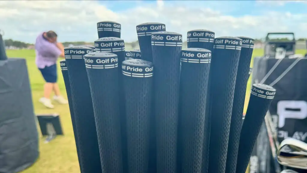 golf grips in a large golf bag shown on a driving range