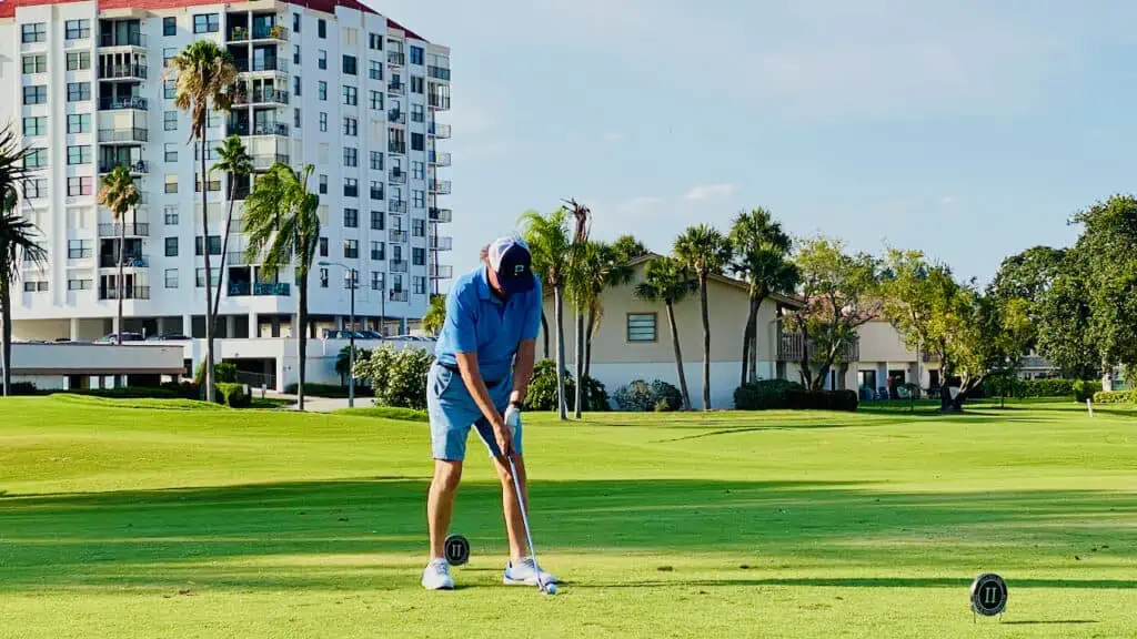 golfer hitting his tee shot with a golf iron. Showing different types of golf clubs.
