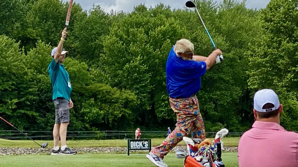 Pro golfer, John Daly practicing to hit the ball off the tee