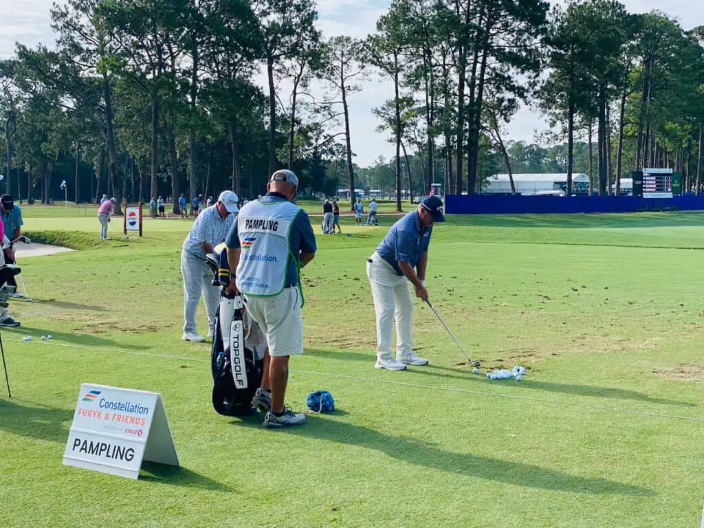 Rod Pampling at Furyk & Friends 2023 Golf Tournament pre-warm up on the driving range with his caddie, Perry Cameron.
