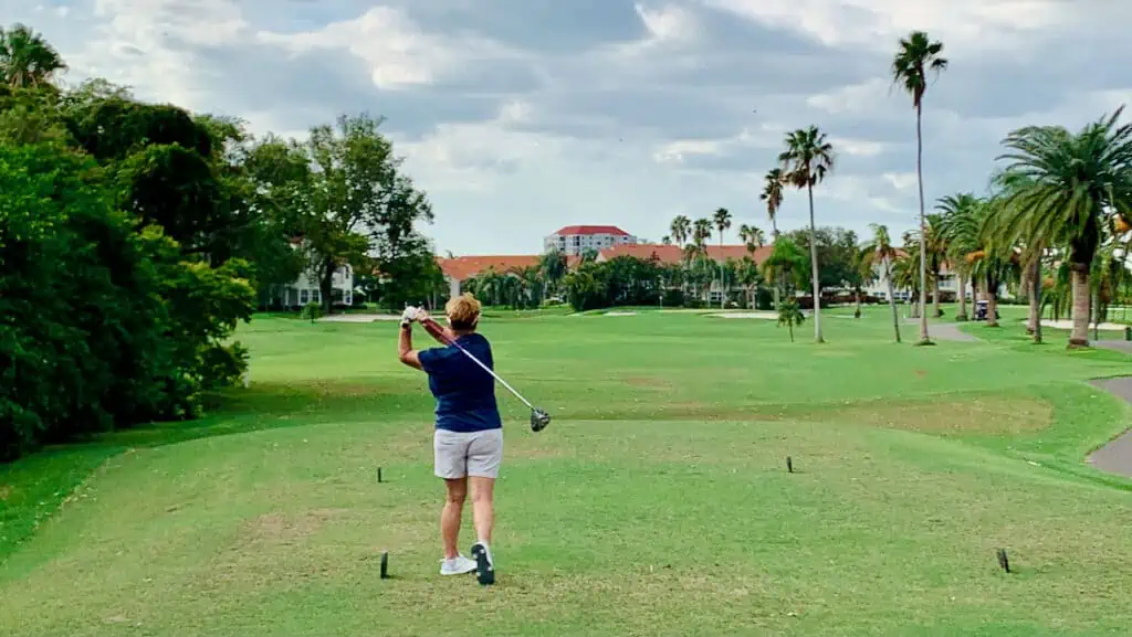 Colleen Gilbert, senior golfer hitting her tee shot with a lightweight driver on a Florida golf course.
