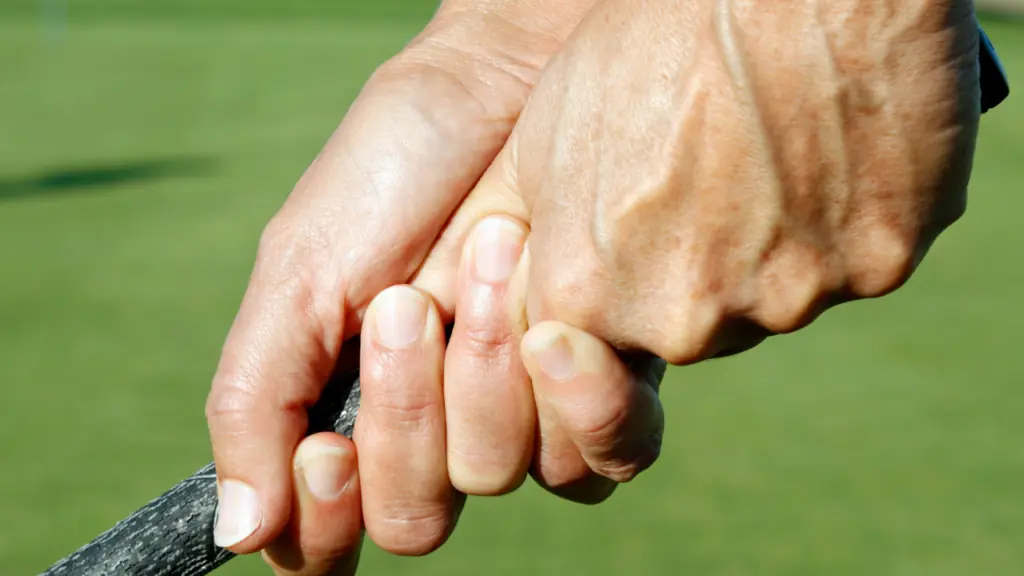 showing a close up of a senior golfer and his golf grip on a club