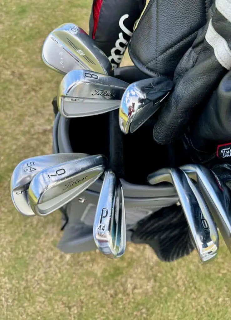 showing his wedges and irons in his golf bag