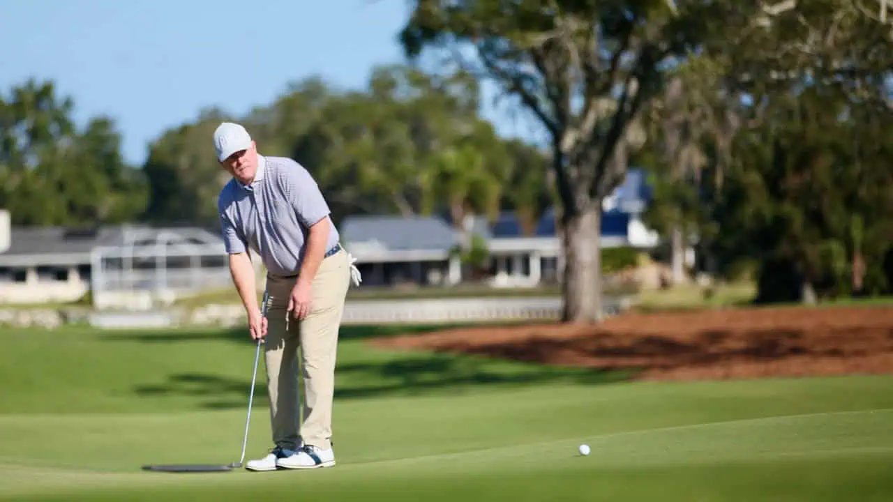 Golf addiction showing the golfer following his put on the green.